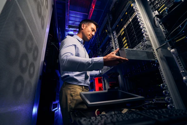 Engineer in data centre looking at rack space